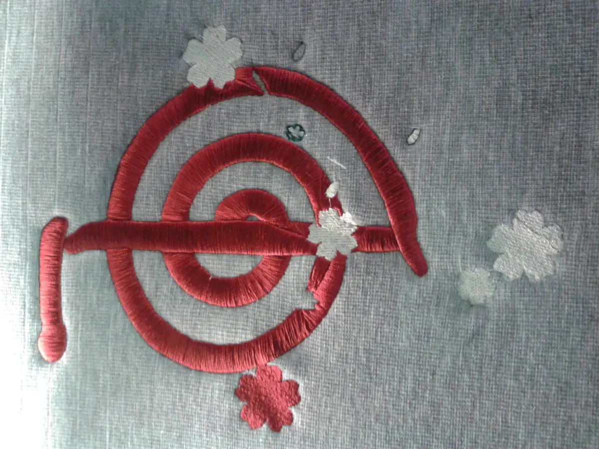 Ricamo: Ricamo rosso spirale su tessuto grigio